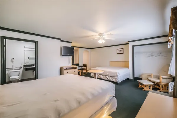 a spacious bedroom with two bed and a mirror