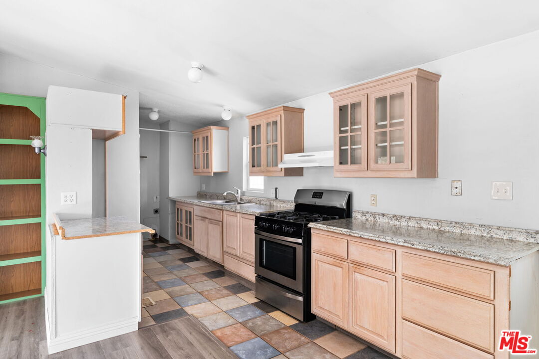4388 Amador Road Phelan, CA 92371 - Photo 26 of 53 a kitchen with granite countertop a sink stove and cabinets