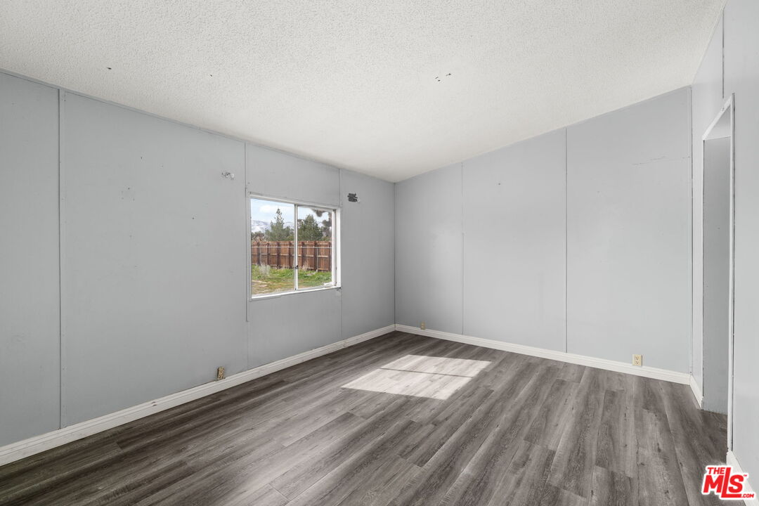 4388 Amador Road Phelan, CA 92371 - Photo 37 of 56 a view of an empty room with wooden floor and a window