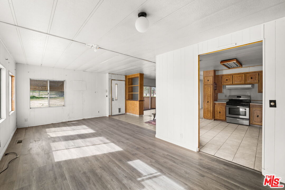 4388 Amador Road Phelan, CA 92371 - Photo 5 of 56 a view of a livingroom with wooden floor and kitchen space