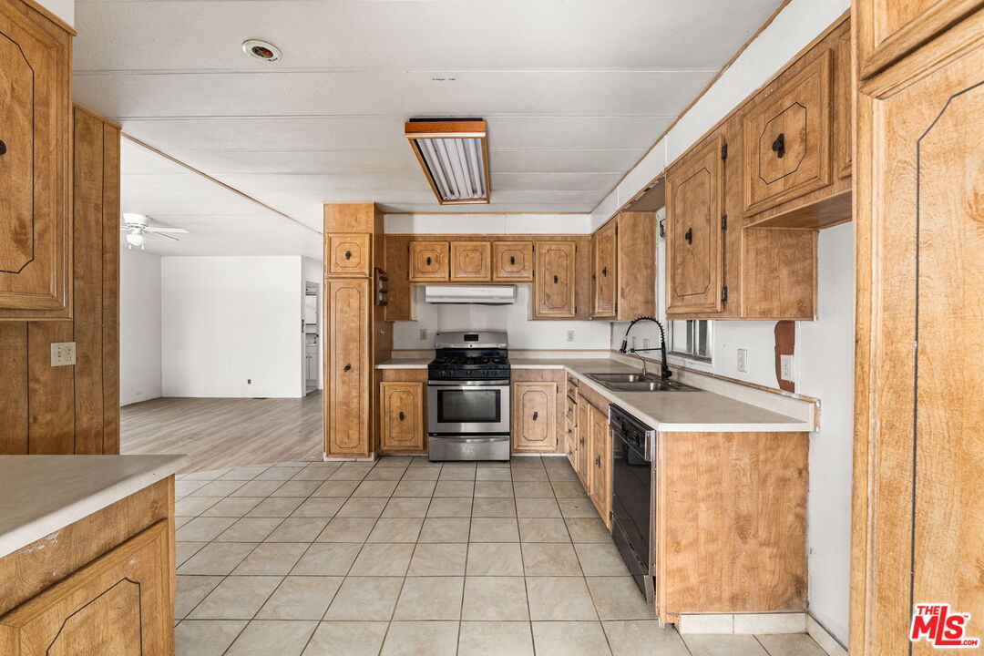 4388 Amador Road Phelan, CA 92371 - Photo 6 of 56 a kitchen with stainless steel appliances granite countertop a sink and a refrigerator