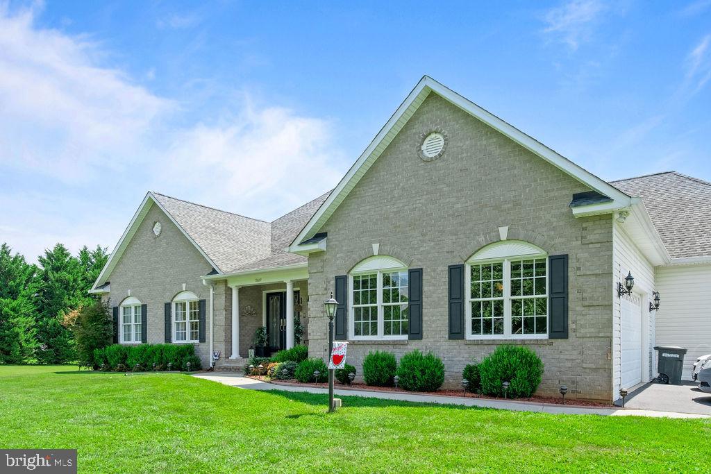 a front view of a house with a yard and plants