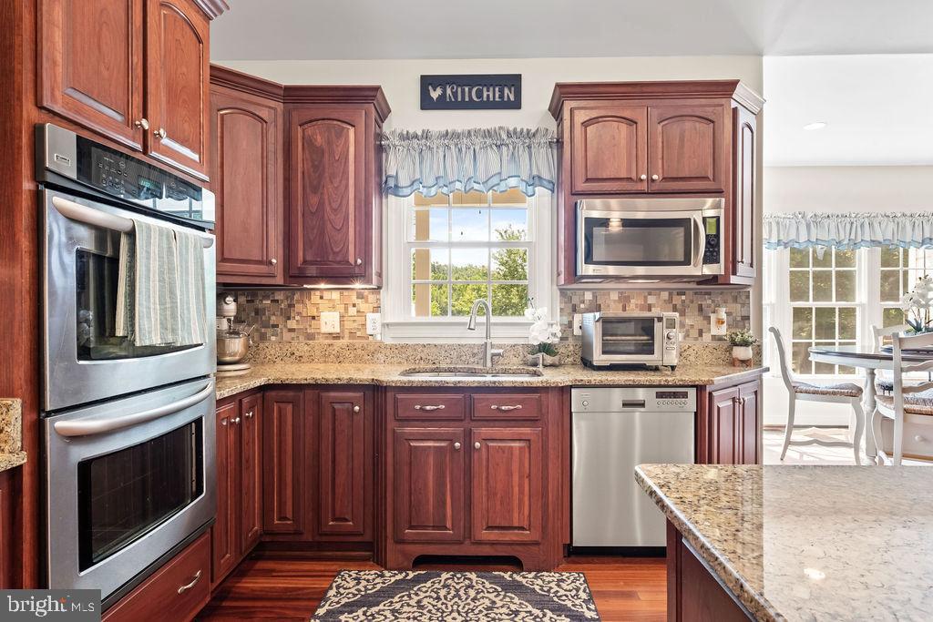 7609 Baileys Road Spotsylvania, VA 22551 - Photo 18 of 111 a kitchen with stainless steel appliances granite countertop a stove microwave and cabinets