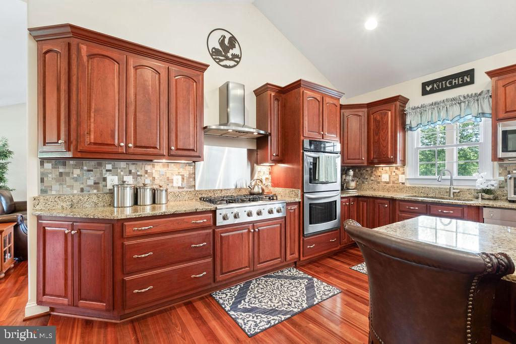 7609 Baileys Road Spotsylvania, VA 22551 - Photo 2 of 111 a kitchen with stainless steel appliances granite countertop a stove a sink dishwasher and wooden cabinets with wooden floor