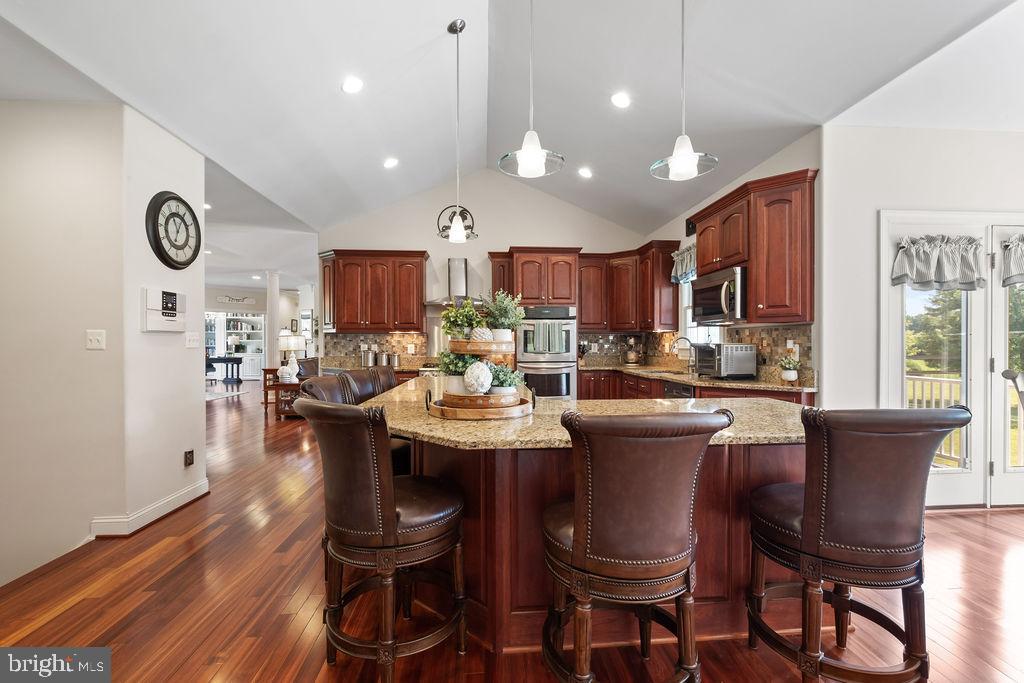 7609 Baileys Road Spotsylvania, VA 22551 - Photo 26 of 111 a kitchen with a dining table chairs cabinets a stove and a window