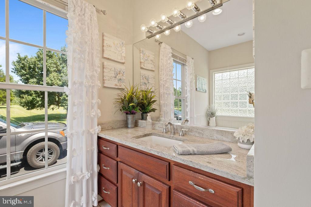 7609 Baileys Road Spotsylvania, VA 22551 - Photo 52 of 111 a bathroom with a granite countertop sink and a large mirror