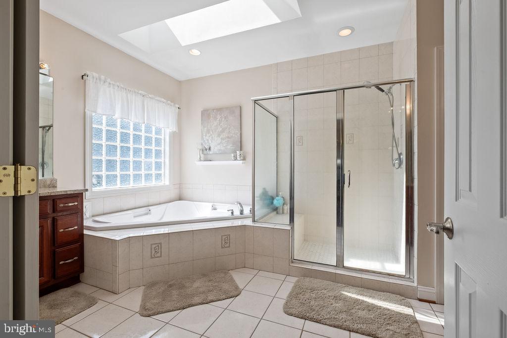 7609 Baileys Road Spotsylvania, VA 22551 - Photo 93 of 111 a spacious bathroom with a tub a sink a mirror and a shower
