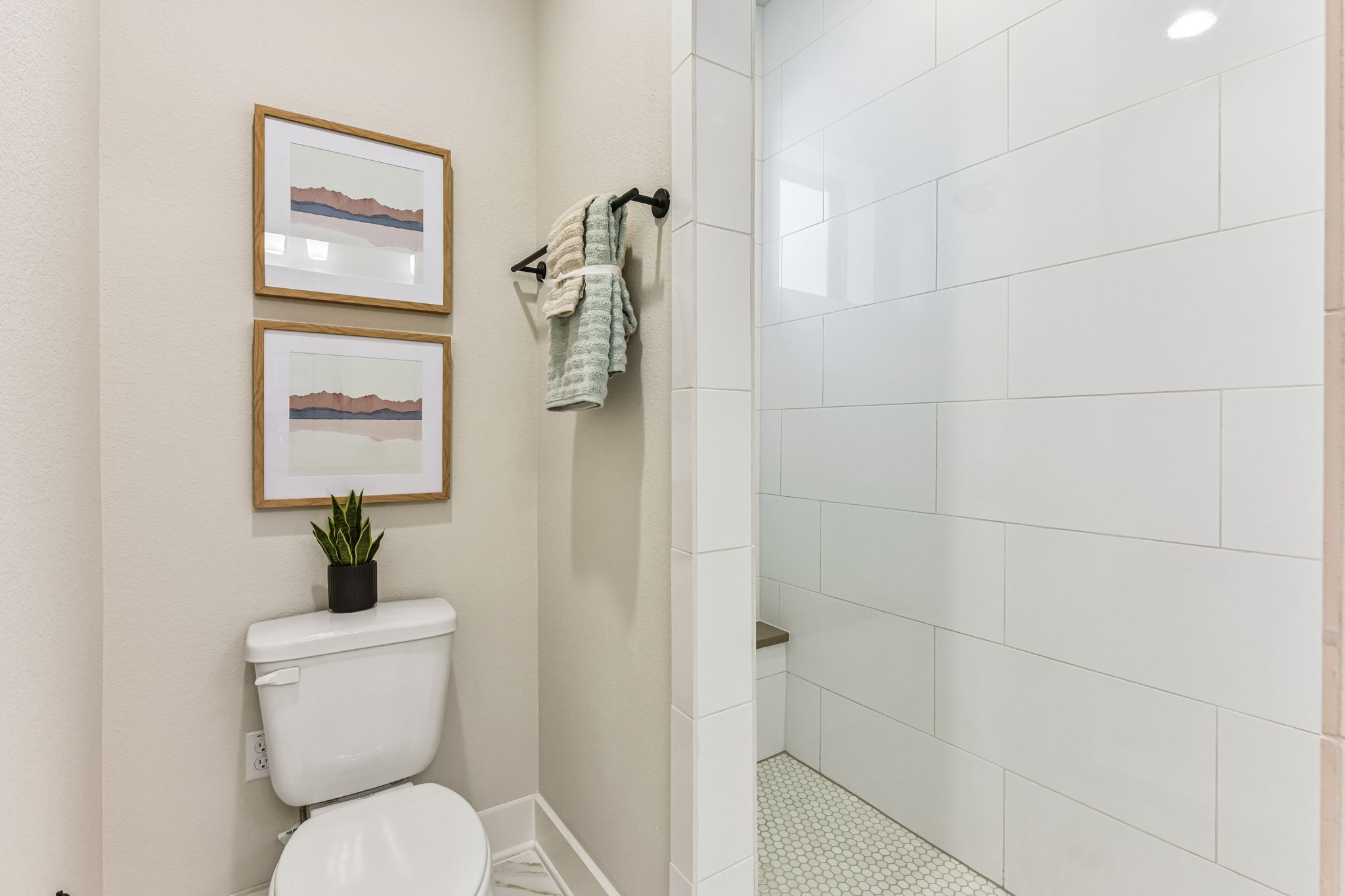 9033 Cattle Baron Path Austin, TX 78747 - Photo 19 of 40 A pristine shower with hex tile flooring adjoins a commode with elegant marble surround.