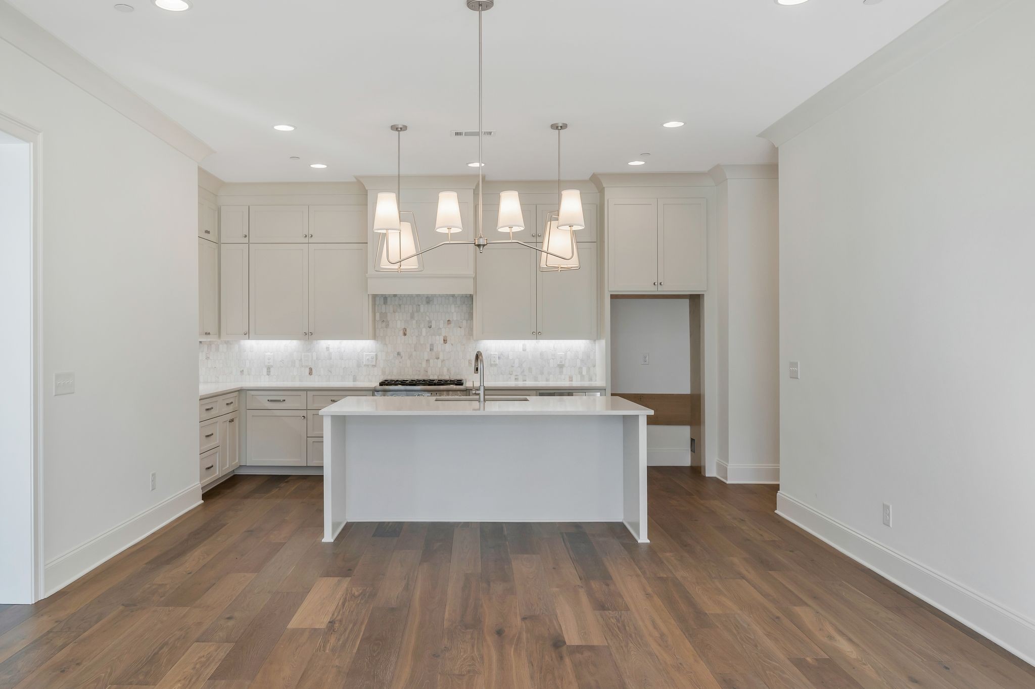 6037 Whitman Road, Unit 203 Franklin, TN 37064 - Photo 21 of 52 a kitchen with kitchen island white cabinets and wooden floor