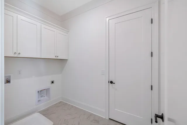 a view of cabinets and utility room with closet