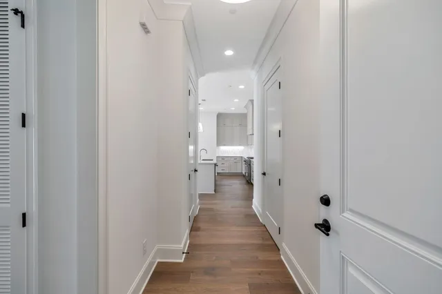 a view of a hallway with wooden floor