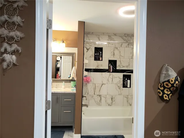 a bathroom with a bathtub sink and mirror