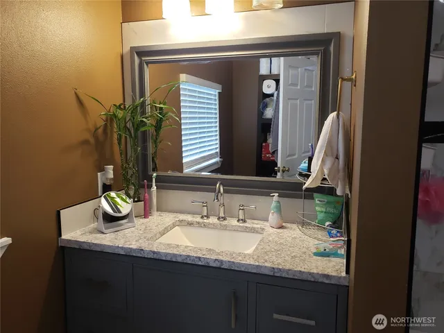 a bathroom with a granite countertop sink and a mirror