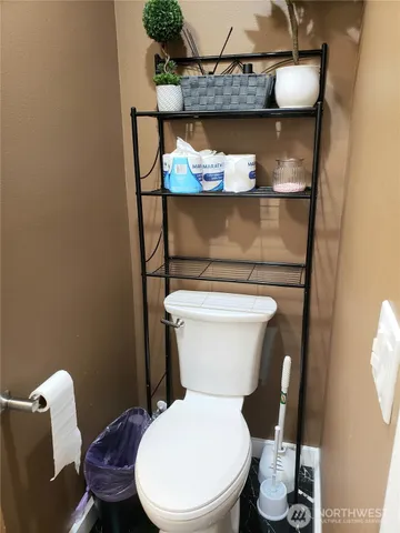 a white toilet sitting next to a wooden cabinet