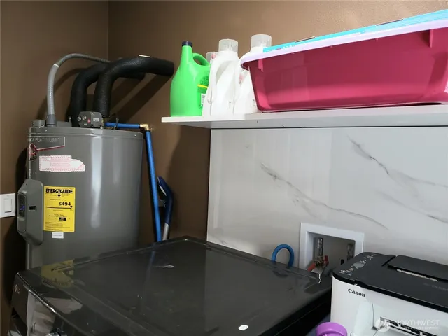 a backyard of a house with large trees and a wooden fence