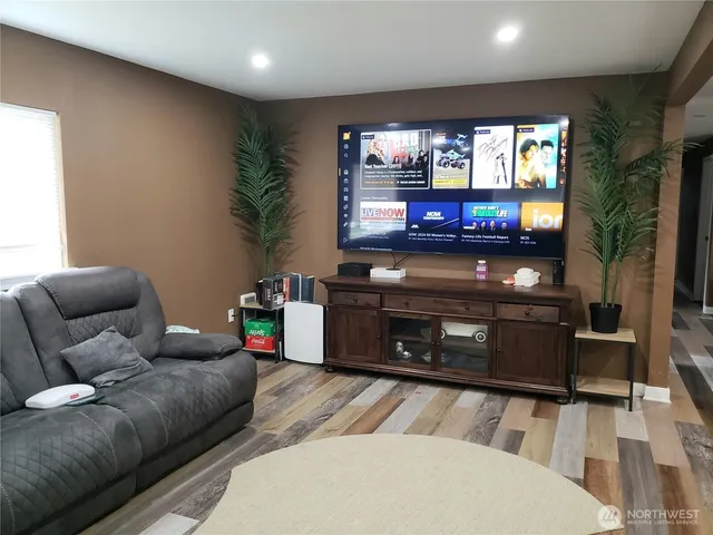 a living room with furniture a flat screen tv and a fireplace