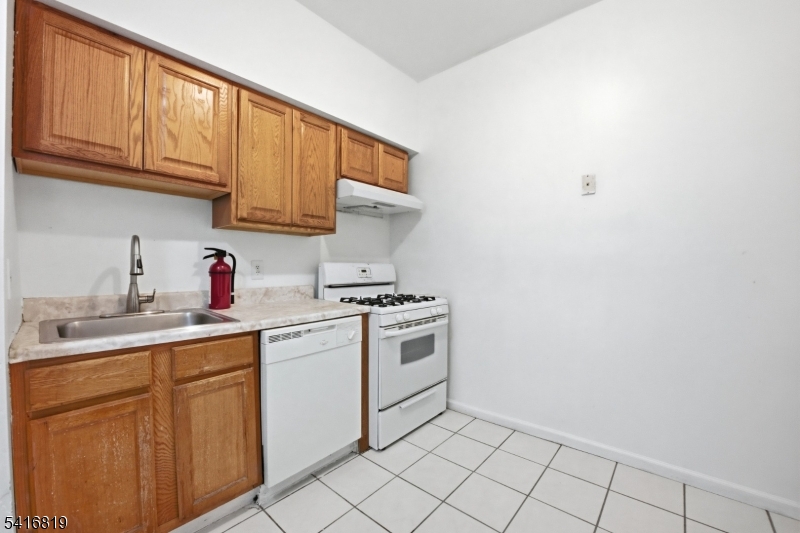 44 3rd Street Newark, NJ 07107 - Photo 2 of 12 a kitchen with a sink cabinets and a window