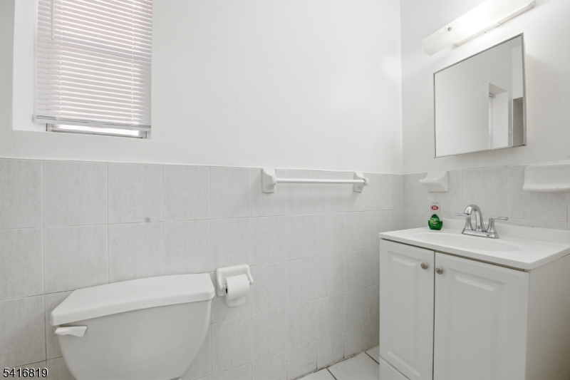 44 3rd Street Newark, NJ 07107 - Photo 8 of 12 a bathroom with a toilet sink and mirror
