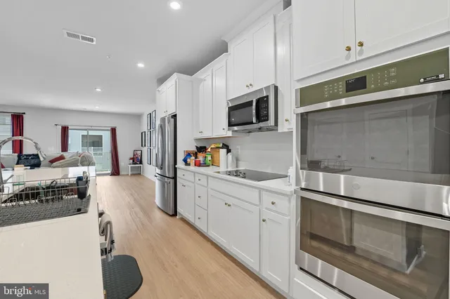 a kitchen with stainless steel appliances a stove microwave and sink