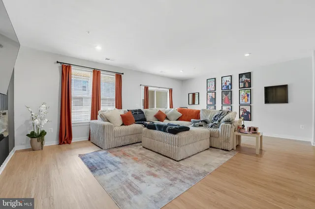a living room with furniture a flat screen tv and a large window