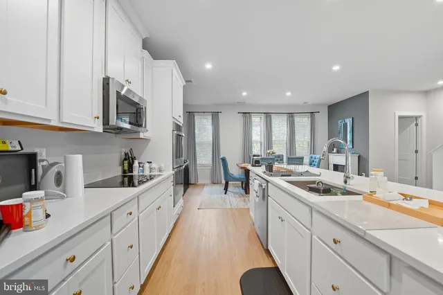 a kitchen with stainless steel appliances granite countertop a sink stove and cabinets