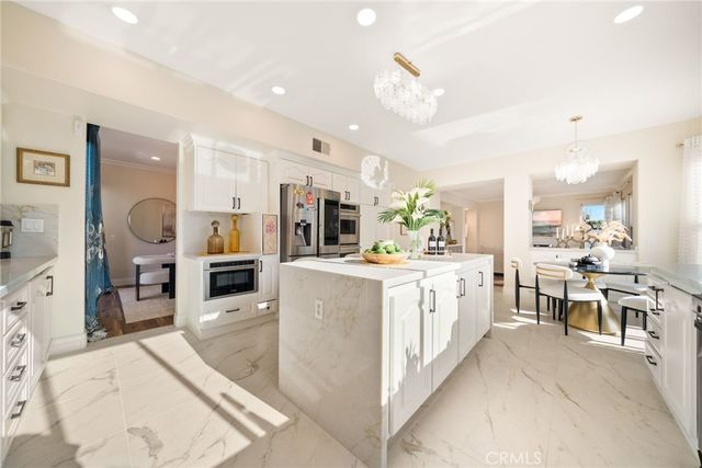 a large white kitchen with lots of counter space and furniture