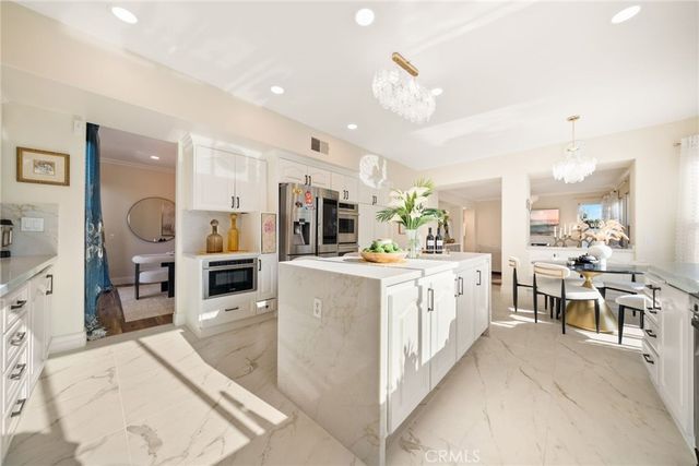 a large white kitchen with lots of counter space and furniture