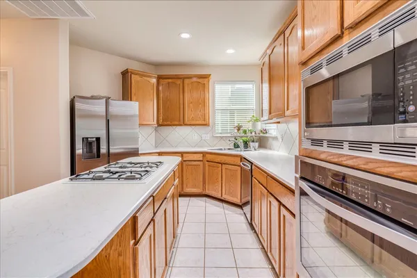 a kitchen with stainless steel appliances granite countertop a sink stove and refrigerator