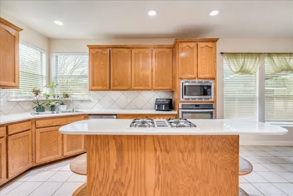 a view of kitchen with stainless steel appliances granite countertop a sink and cabinets