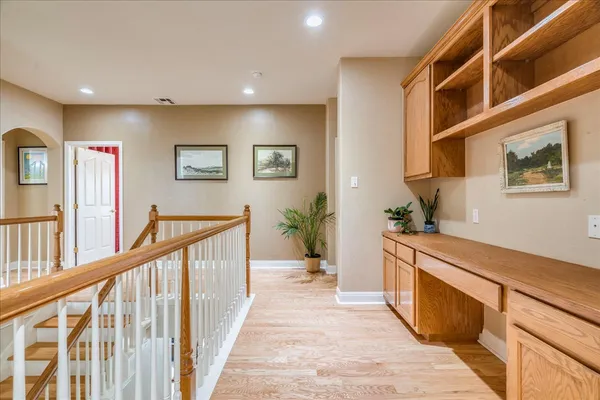 a view of a hallway with wooden floor and windows