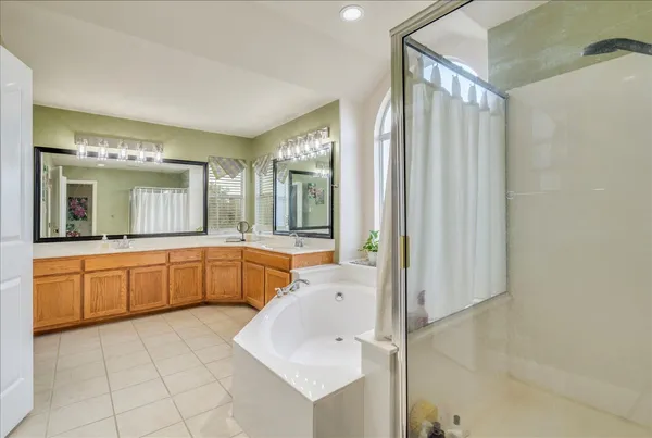 a large bathroom with a tub a sink and mirror