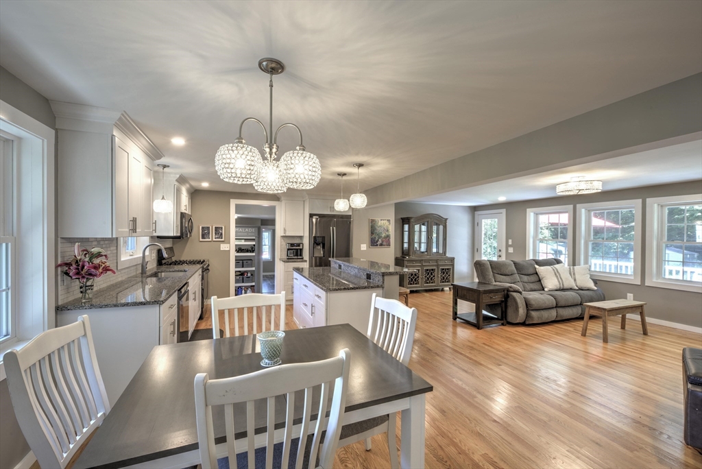 428 Bridge Road Northampton, MA 01062 - Photo 12 of 42 a view of a dining room and livingroom with furniture wooden floor a chandelier