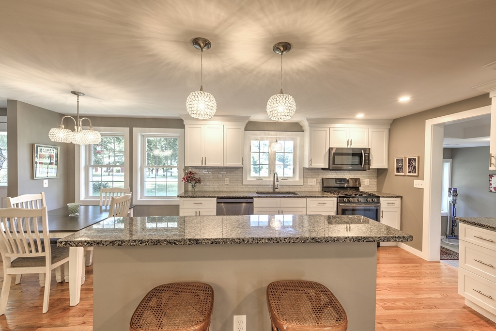 428 Bridge Road Northampton, MA 01062 - Photo 9 of 42 a kitchen with stainless steel appliances granite countertop a stove a sink a refrigerator and chairs