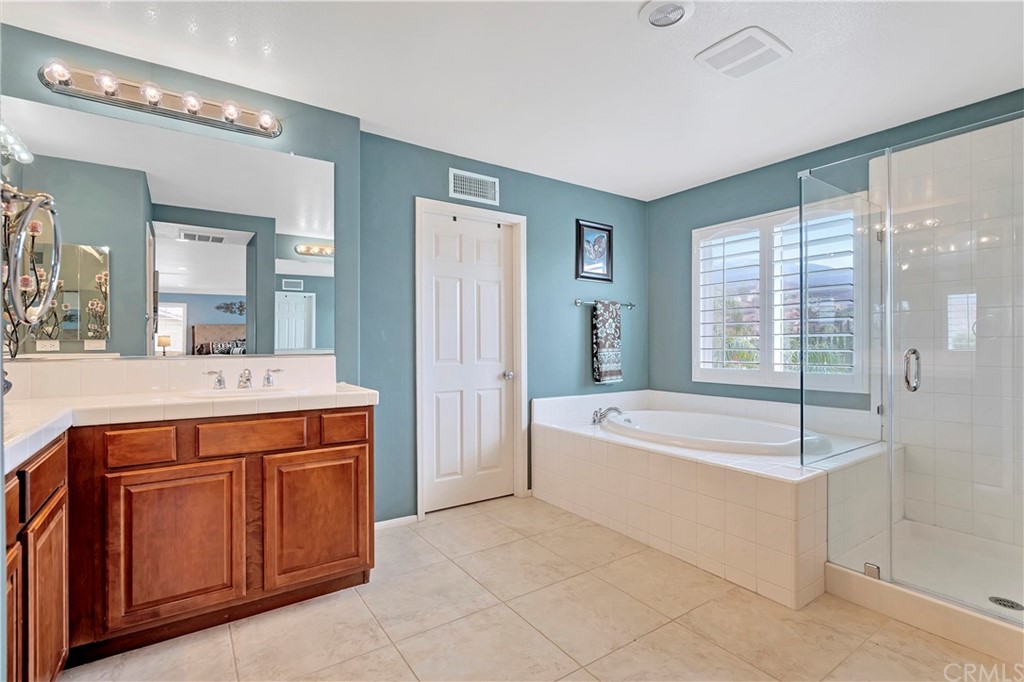 3426 Amethyst Street Corona, CA 92882 - Photo 37 of 72 a spacious bathroom with a tub sink and mirror