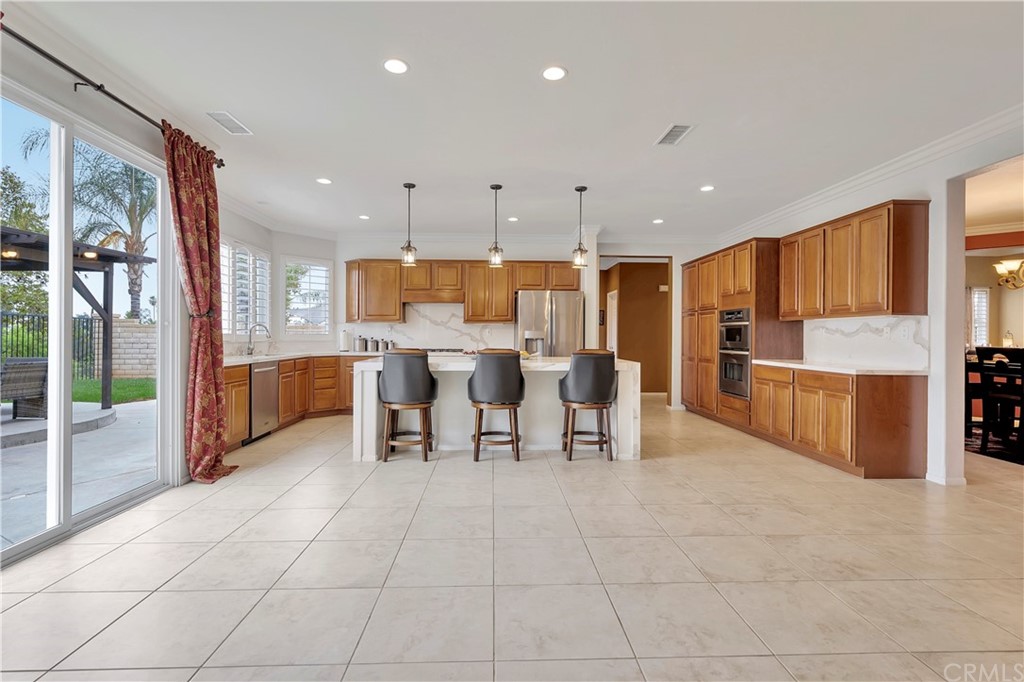 3426 Amethyst Street Corona, CA 92882 - Photo 55 of 72 a large kitchen with stainless steel appliances lots of counter space and furniture