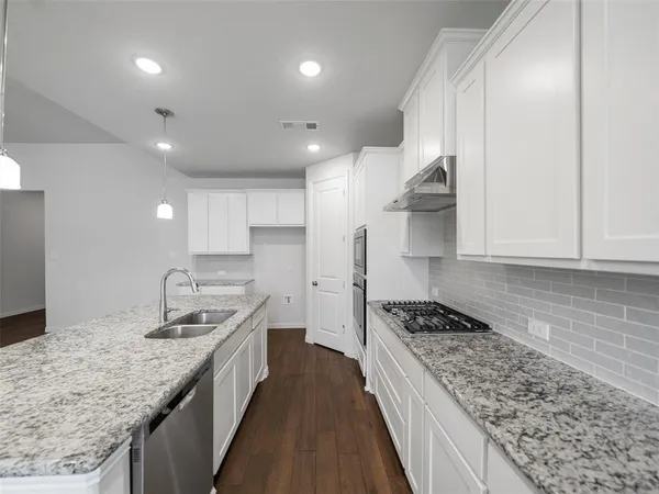 a kitchen with a sink stove and cabinets