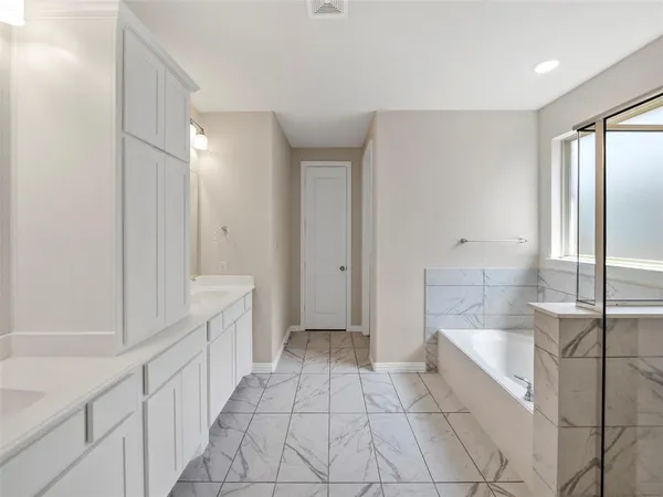 a bathroom with a bathtub a shower and a sink