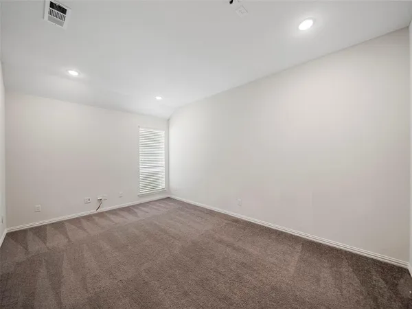 an empty room with wooden floor chandelier and windows