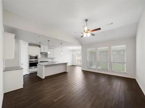 a kitchen with kitchen island a sink and a stove top oven