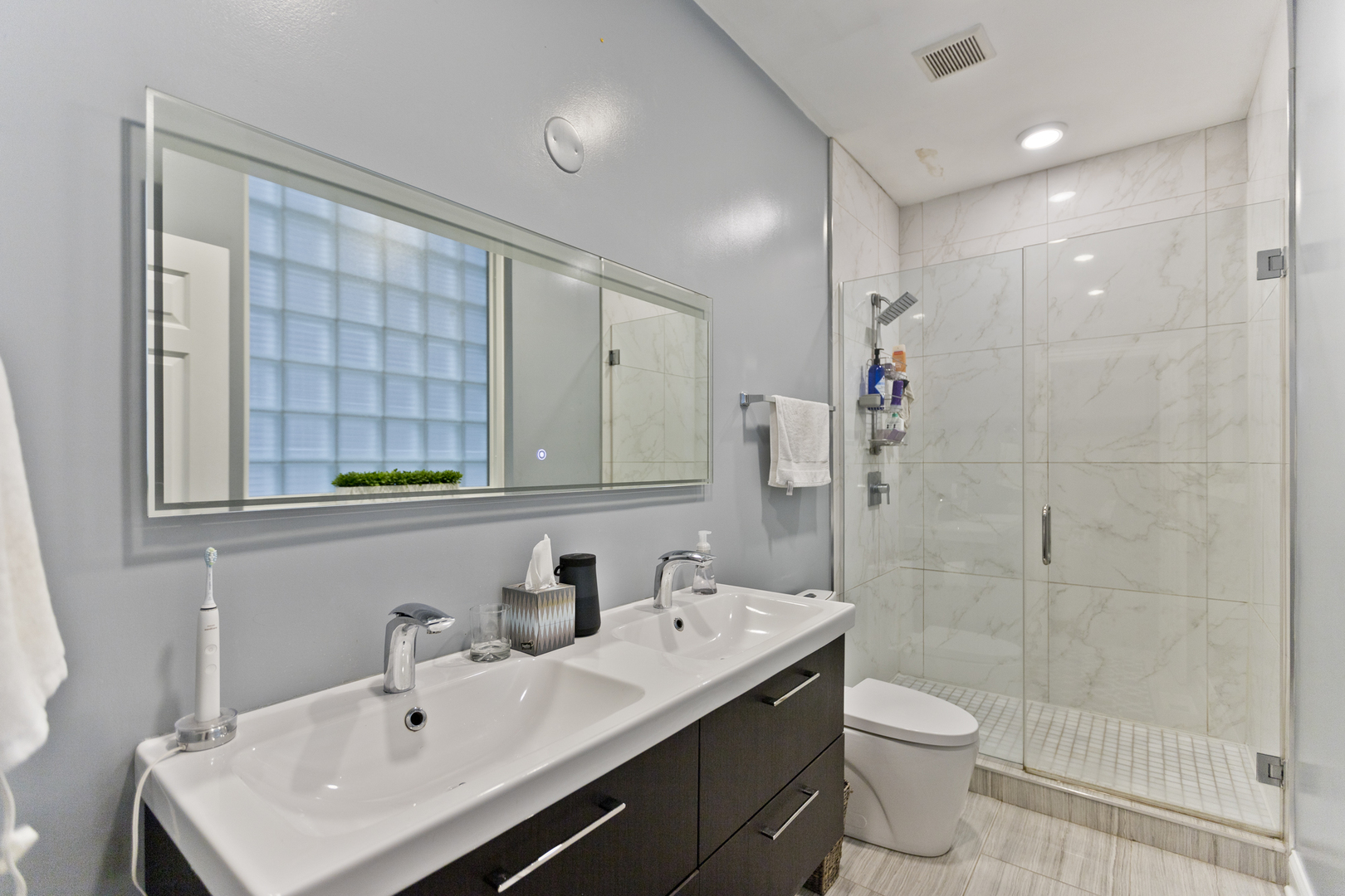Undisclosed Address Chicago, IL 60614 - Photo 13 of 21 a bathroom with a sink toilet a mirror and shower