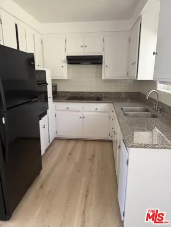 a kitchen with granite countertop a sink and a stove top oven