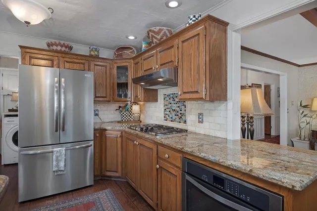 a kitchen with stainless steel appliances granite countertop a refrigerator and a sink