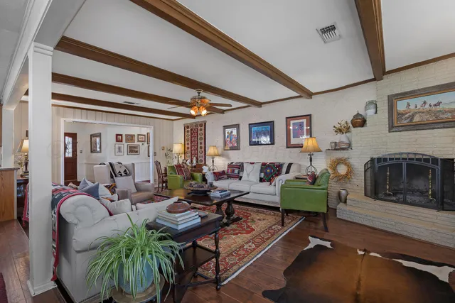 a living room with furniture a flat screen tv and a fireplace
