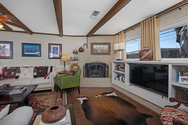 a living room with furniture a flat screen tv and a fireplace