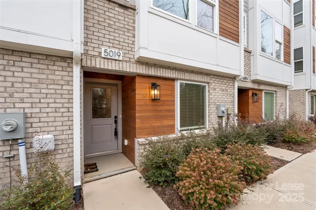 front view of a brick house with a small yard