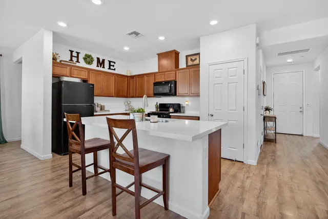 a kitchen with stainless steel appliances granite countertop a refrigerator and a stove top oven