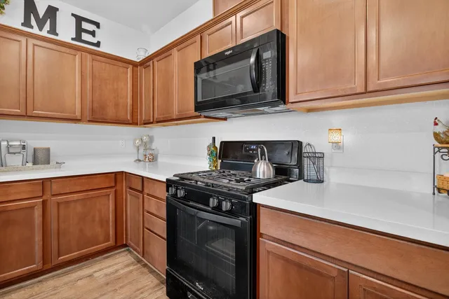 a kitchen with stainless steel appliances granite countertop a sink a stove and cabinets
