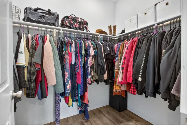 a view of walk in closet with clothes