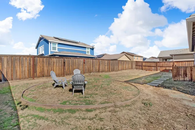 a backyard of a house with table and chairs