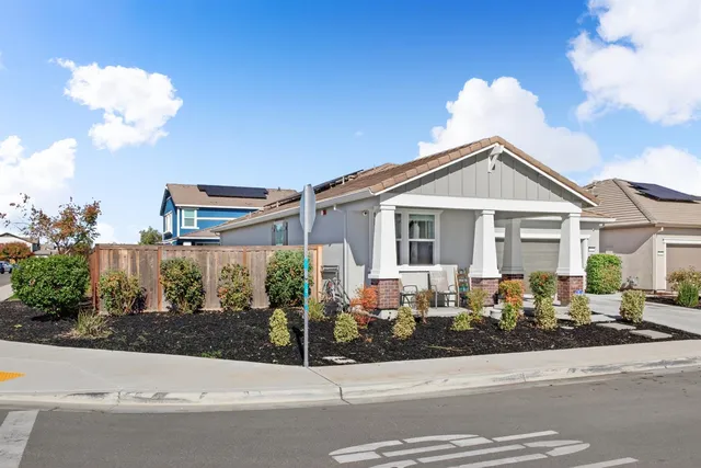 a front view of a house with a small yard and potted plants